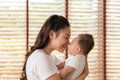 Asian mom holding her baby newborn in hand and kissing on baby nose sweet and lovely.Good moment of Happy mother and infant baby Royalty Free Stock Photo