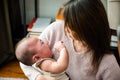 Asian mom holding her crying little baby at home Royalty Free Stock Photo