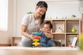 Asian mom teaching baby boy learning and playing toys for development skill at home or nursery room. Happiness mother and baby Royalty Free Stock Photo