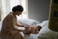 Asian mom wearing dress changes the baby`s diaper in the bedroom Royalty Free Stock Photo