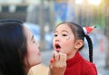 Asian mother applying lipstick over daughter mouth Royalty Free Stock Photo