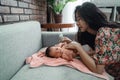 Asian mother applying telon oil to her little daughter