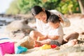 Asian mother and baby play sand and toy togather