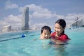 Asian Mother and baby swim in the roof top pool Royalty Free Stock Photo