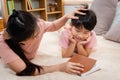 Asian mother and boy, wearing a pink t-shirt, The two of them lay comfortably on the bed, with a book in her mother`s hand, The Royalty Free Stock Photo