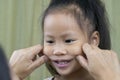 Asian mother and child girl playing pinch cheeks, touch nose funny face