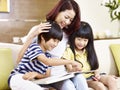 Asian mother and children reading a book together Royalty Free Stock Photo