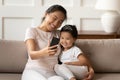 Asian mother cuddles little daughter holding smartphone takes selfie photography Royalty Free Stock Photo