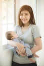 Asian Mother Cuddling Baby Daughter At Home In Front Of Window Royalty Free Stock Photo