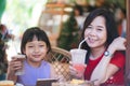 Asian mother and daughter drinking and smiling with happiness Royalty Free Stock Photo