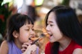 Asian mother and daughter eating sausage with happiness Royalty Free Stock Photo