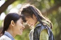 Asian mother and daughter having a good time outdoors in park Royalty Free Stock Photo