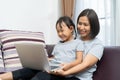 Asian mother and daughter using laptop studying homework online lesson at home Royalty Free Stock Photo