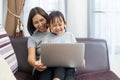 Asian mother and daughter using laptop studying homework online lesson at home Royalty Free Stock Photo