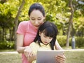 Asian mother and daughter using tablet computer Royalty Free Stock Photo