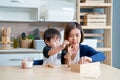 Asian mother enjoy to play wooden jigsaw puzzle together in area of kitchen of their house and they look happiness