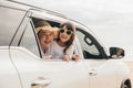 Asian mother father and children smiling sitting in compact white car looking out windows Royalty Free Stock Photo