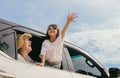 Asian mother father and children smiling sitting in compact white car looking out windows Royalty Free Stock Photo