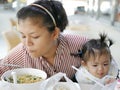 Asian mother feeding both herself and her baby girl, one year old Royalty Free Stock Photo