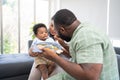 Asian mother feeding her 9 months old her cute little baby and African American helping for holding food plate At Home. Photo Royalty Free Stock Photo