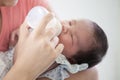 Asian mother feeding her newborn baby girl with milk bottle Royalty Free Stock Photo