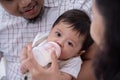 Asian mother feeding son with milk in baby bottle Royalty Free Stock Photo