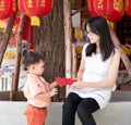 Asian mother give a red envelope or Ang-pow to son