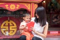 Asian mother give red envelope or Ang-pow to son Royalty Free Stock Photo