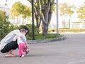 Asian mother help toddler wearing shoes.