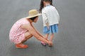 Asian mother helping her little daughter to put shoes on the road outdoor Royalty Free Stock Photo