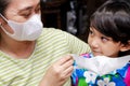 Asian mother helping cute little boy using face mask