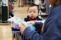 Asian mother and her baby shopping in clothing store Royalty Free Stock Photo