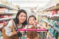 Asian mother and her daughter buying food at huge supermarket , Baby sit in trolley, Family shopping concept Royalty Free Stock Photo