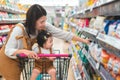 Asian mother and her daughter buying food at huge supermarket , Baby sit in trolley, Family shopping concept Royalty Free Stock Photo