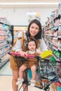 Asian mother and her daughter buying food at huge supermarket ,Hand holding a product box mockup ready for retouch, Royalty Free Stock Photo