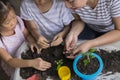 Asian mother and her kids gardening together. Spring and hobbies, family grows flowers together. Hobby home for whole family, Royalty Free Stock Photo