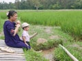 Asian mother and her little baby girl enjoy spending time together in a rice field Royalty Free Stock Photo