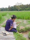 Asian mother and her little baby girl enjoy spending time together in a rice field Royalty Free Stock Photo