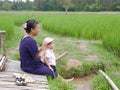 Asian mother and her little baby girl enjoy spending time together in a rice field