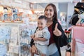 asian mother with her toddler boy shopping in the baby shop with thumb up Royalty Free Stock Photo