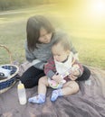 Asian Mother hold baby when family picnic in the park Royalty Free Stock Photo