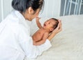 Asian mother hold her little newborn baby from bed and talk to each other and look happy Royalty Free Stock Photo