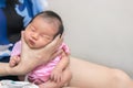 Asian mother hold tiny newborn baby with hand for help infant belch after breastfeeding milk to heal gas pain or indigestion, Royalty Free Stock Photo