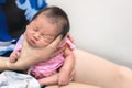 Asian mother hold tiny newborn baby with hand for help infant belch after breastfeeding milk to heal gas pain or indigestion,