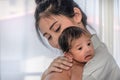 Asian mother holding her cute infant baby boy on her shoulder Royalty Free Stock Photo