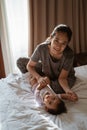 Asian mother holding a little daughter hands on the bed Royalty Free Stock Photo