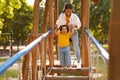 Asian Mother With Infant Daughter Walking Swinging Bridge On Playground Royalty Free Stock Photo