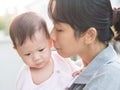 Asian mother kiss baby in morning.
