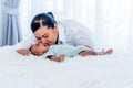 Asian mother kissing her 1-month-old baby newborn son, half Thai half Nigerian who is lying in white bed Royalty Free Stock Photo