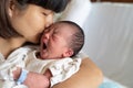 Asian mother kissing her newborn baby Royalty Free Stock Photo